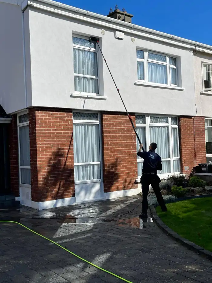 Washing the render and upstairs windows of a semi-detached house with a water-fed pole